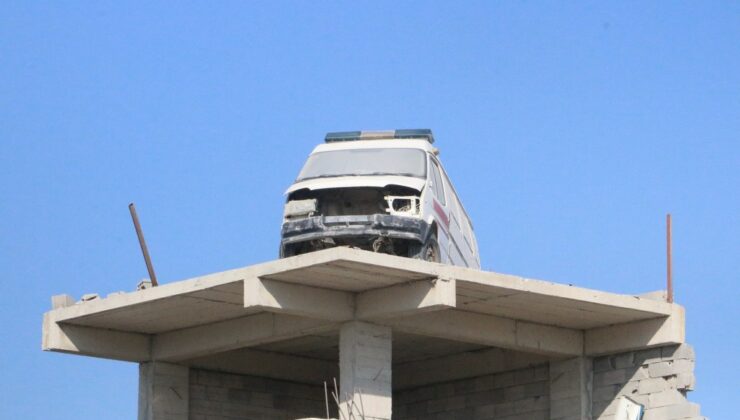 Hatay’da Ağır Hasarlı İş Yerinin Çatısında Dikkat Çeken Minibüs
