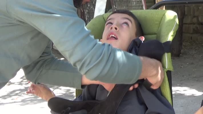 Demir ustası baba, serebral palsili oğlunu yaptığı özel sehpayla gezdiriyor