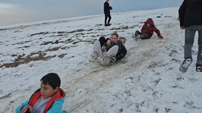 Çocuklar tepsi ve plastik bidonlarla kayarak eğlendi