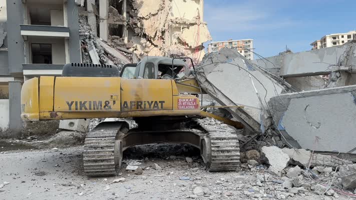 Yıkım sırasında bina iş makinesinin üzerine devrildi