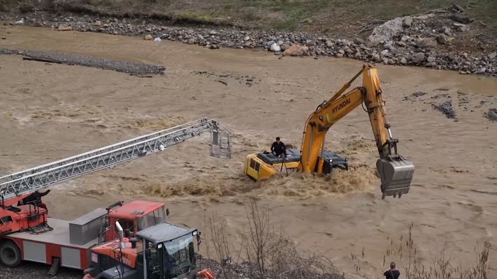 Debisi yükselen çayda mahsur kalan operatörü itfaiye kurtardı